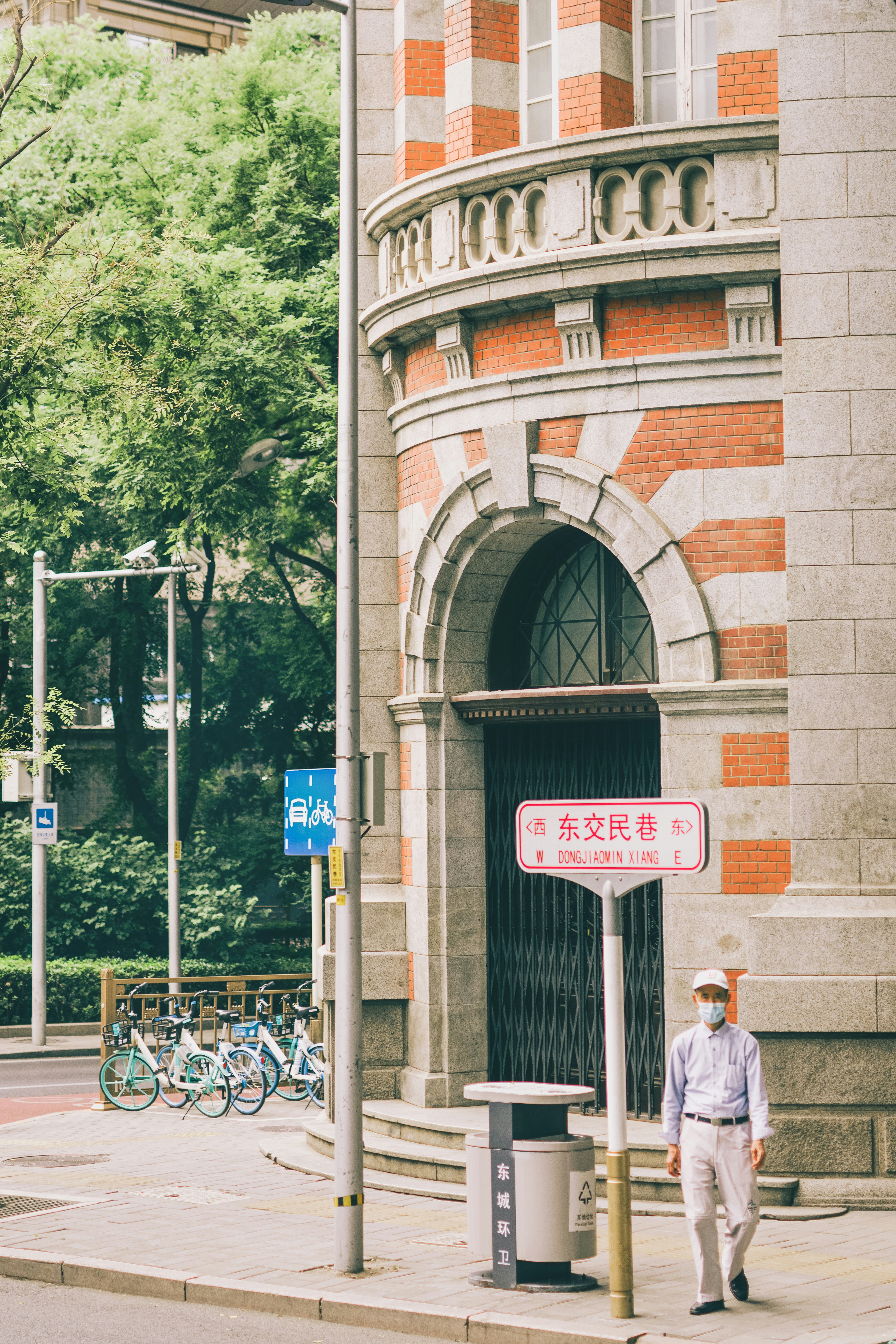 man in white dress shirt and gray pants standing beside gray steel fence during daytime